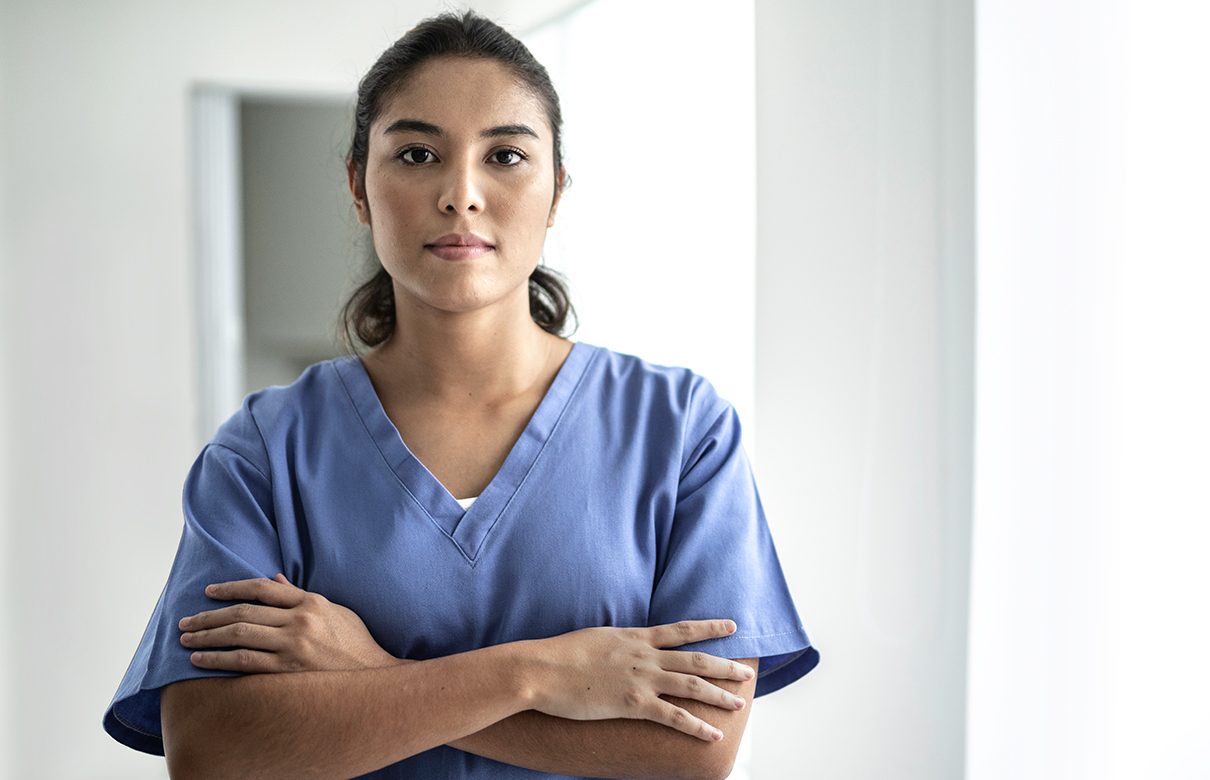 Terveydenhuollon työntekijä kädet ristissä.